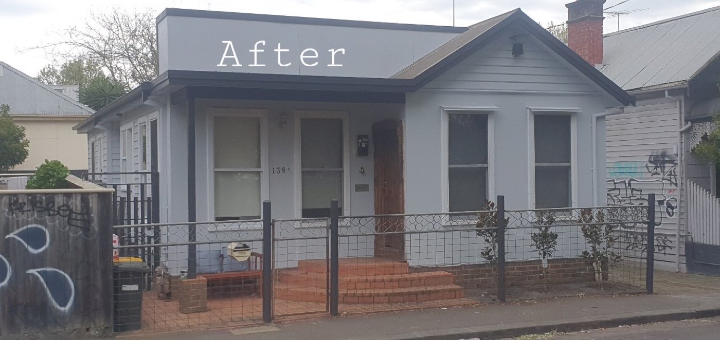 The weatherboard cottage after painting, in fresh blue-grey with white trim