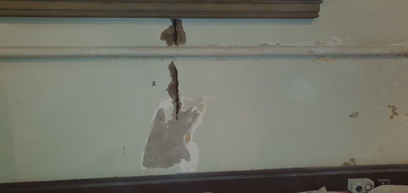 A cracked plaster wall before repair